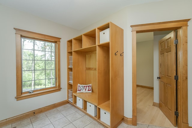 mudroom featuring a healthy amount of sunlight, light tile patterned floors, and baseboards