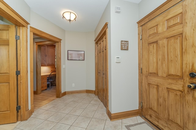 hall with light tile patterned floors and baseboards