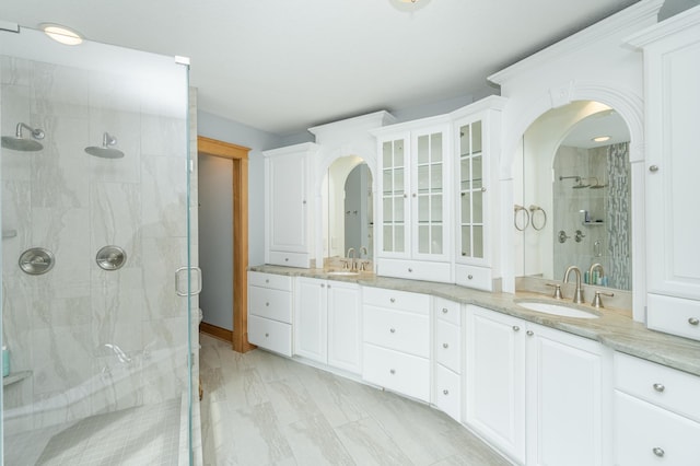 bathroom featuring double vanity, a shower stall, and a sink