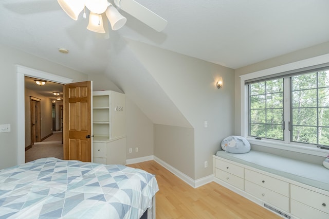 bedroom featuring a ceiling fan, light wood-type flooring, lofted ceiling, and baseboards