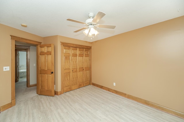 unfurnished bedroom featuring ceiling fan, a closet, light wood-type flooring, and baseboards