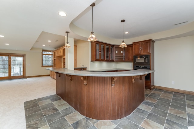 kitchen with recessed lighting, a peninsula, black appliances, a kitchen bar, and glass insert cabinets