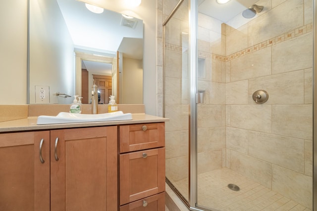 bathroom with visible vents, a shower stall, and vanity