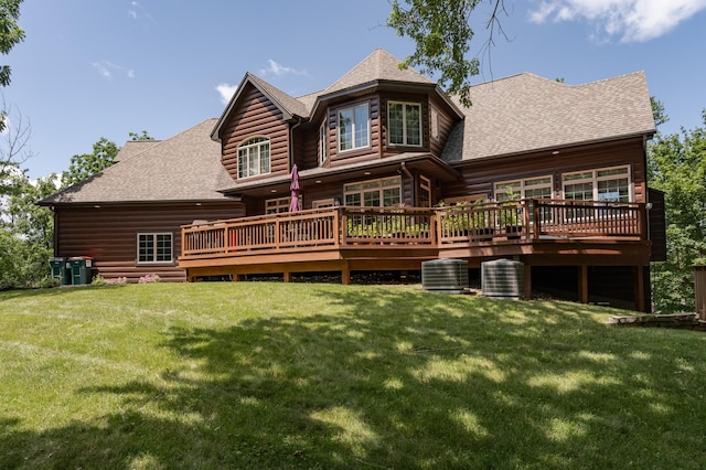 back of property featuring a deck, a yard, a shingled roof, and cooling unit