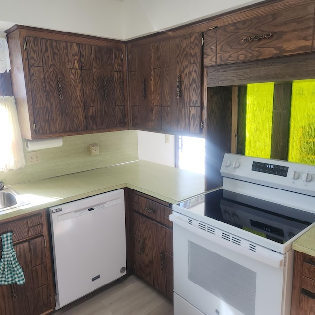 kitchen with white appliances, light countertops, and dark brown cabinets