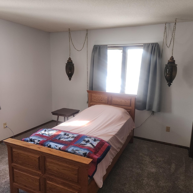 bedroom featuring baseboards and dark carpet