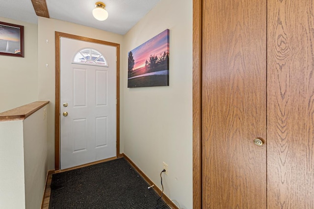 doorway featuring baseboards