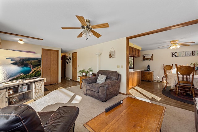 living area with dark wood-type flooring and ceiling fan