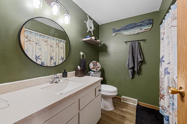 full bathroom featuring toilet, wood finished floors, vanity, visible vents, and baseboards