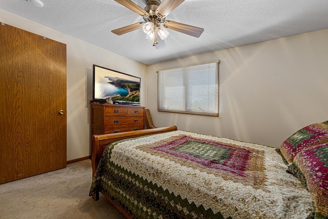 bedroom featuring baseboards, a ceiling fan, a textured ceiling, and light colored carpet