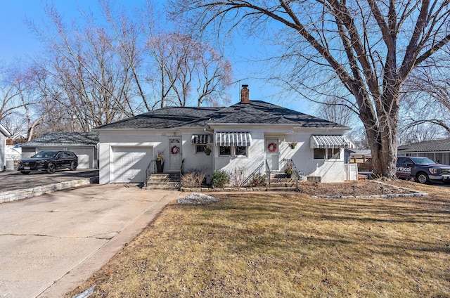 view of front of property featuring driveway, a front lawn, a chimney, and stucco siding