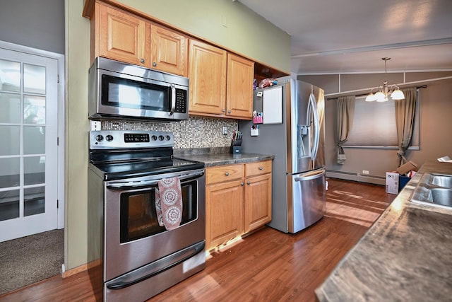 kitchen featuring stainless steel appliances, dark wood-type flooring, dark countertops, and backsplash