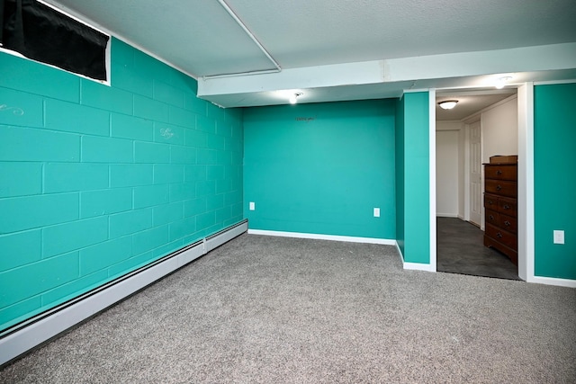 finished below grade area with concrete block wall, baseboards, dark carpet, and baseboard heating