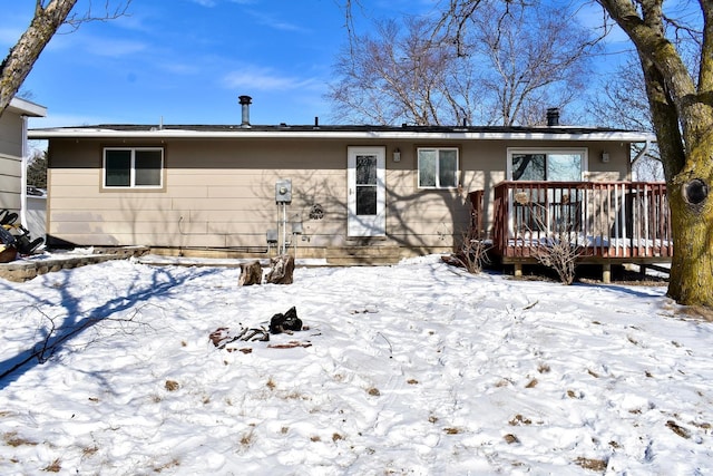 snow covered rear of property featuring a wooden deck