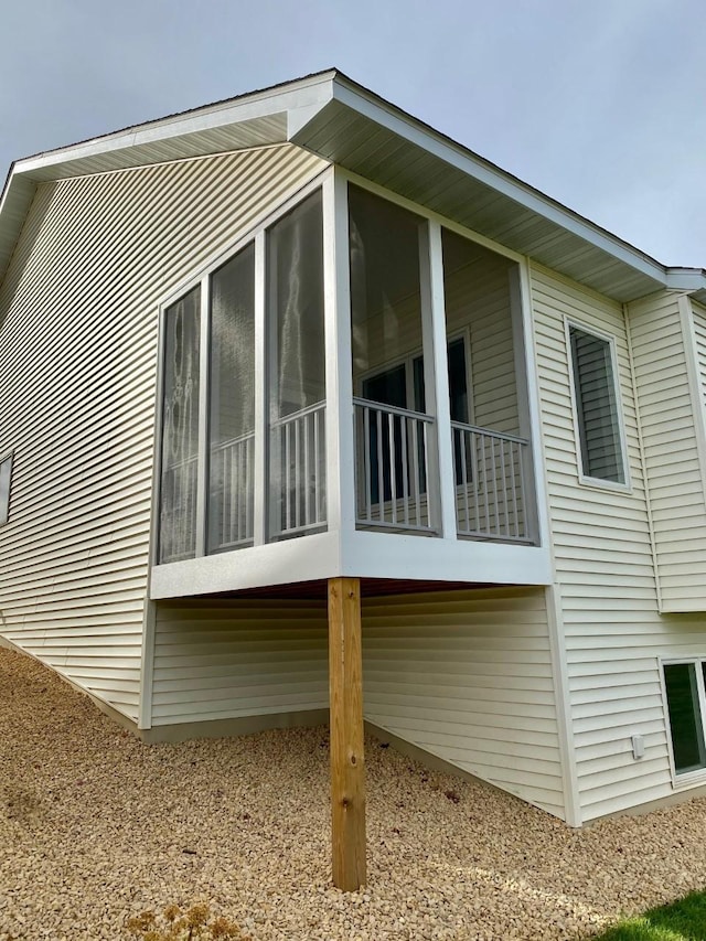 view of property exterior with a sunroom