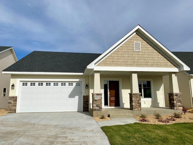 craftsman inspired home with a garage, concrete driveway, stone siding, roof with shingles, and a porch