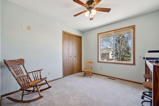 sitting room featuring baseboards, visible vents, a ceiling fan, light colored carpet, and a textured ceiling