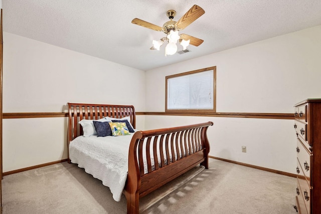 carpeted bedroom featuring a textured ceiling, visible vents, and baseboards