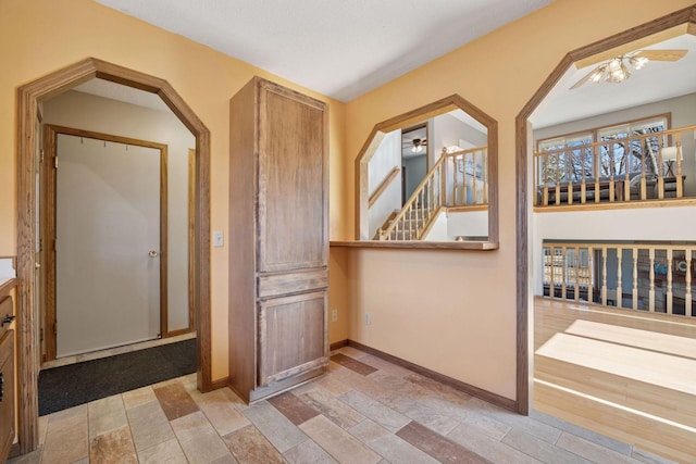 corridor featuring baseboards and stairs