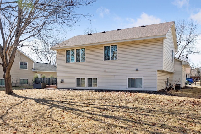 rear view of property with a shingled roof and central AC