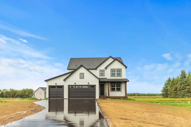 modern inspired farmhouse featuring driveway, a garage, board and batten siding, and roof with shingles