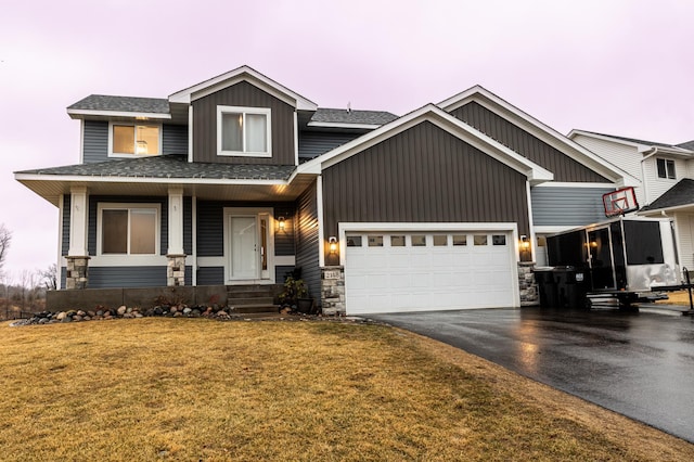 view of front facade with driveway, a garage, a shingled roof, board and batten siding, and a front yard