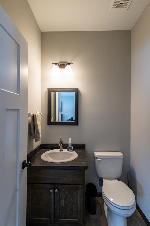 bathroom with toilet, baseboards, visible vents, and vanity