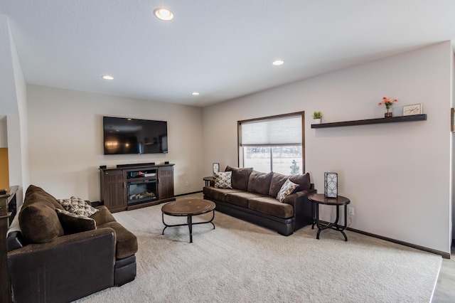 living room featuring baseboards, carpet floors, a glass covered fireplace, and recessed lighting