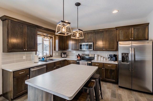 kitchen with stainless steel appliances, a sink, backsplash, and dark brown cabinetry