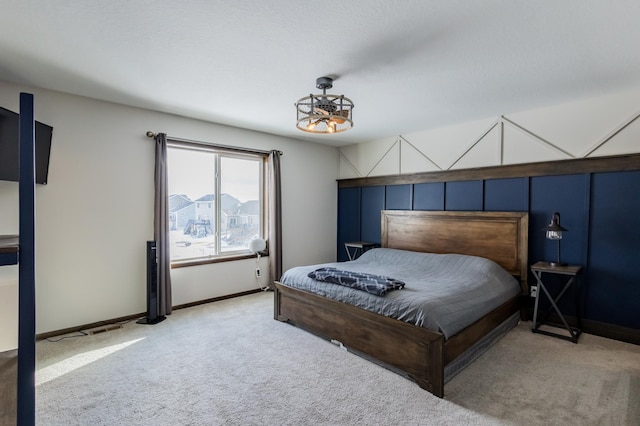 bedroom with baseboards and light colored carpet