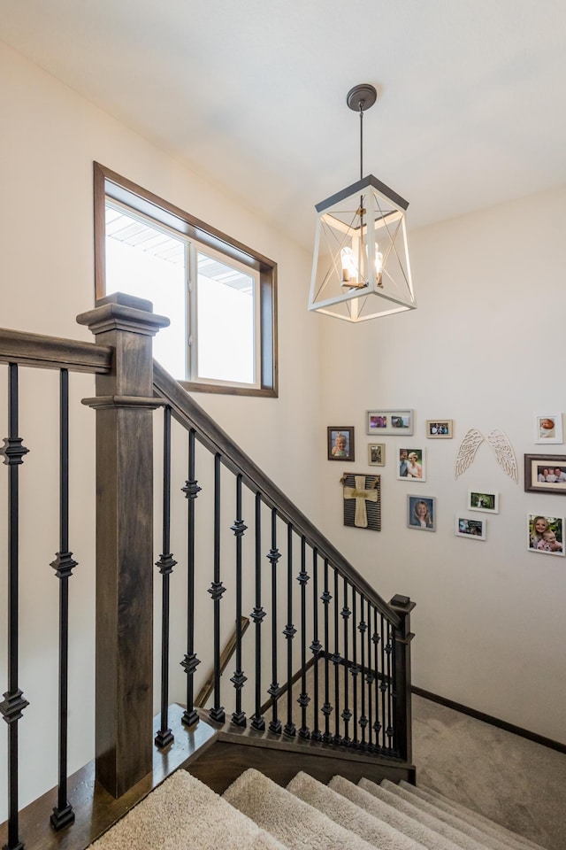 stairs with a notable chandelier