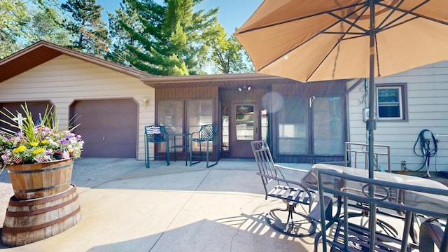 14070 County 18, Park Rapids, MN 56470 - view of patio with concrete driveway, outdoor dining space, and an attached garage