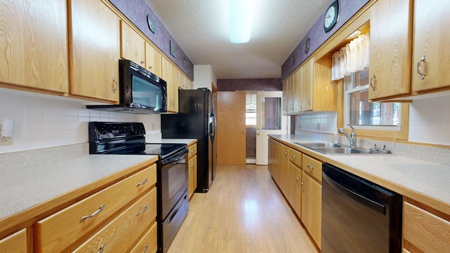 14070 County 18, Park Rapids, MN 56470 - kitchen with black appliances, a sink, light countertops, light wood-style floors, and a textured ceiling