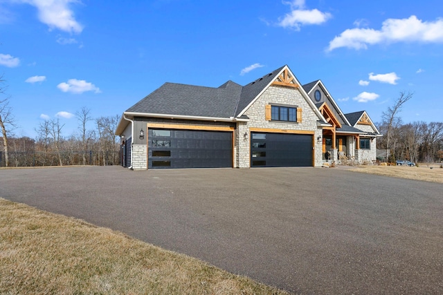 19986 Unity St NW, Oak Grove, MN 55011 - view of front of home featuring a garage, fence, stone siding, roof with shingles, and driveway