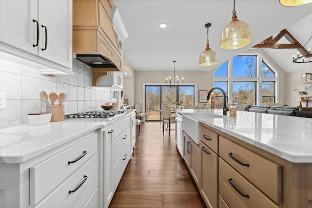 19986 Unity St NW, Oak Grove, MN 55011 - kitchen featuring tasteful backsplash, stainless steel gas cooktop, a sink, custom exhaust hood, and a notable chandelier