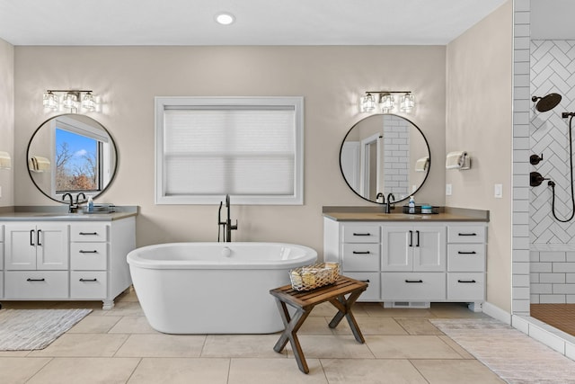 19986 Unity St NW, Oak Grove, MN 55011 - bathroom with tile patterned flooring, a freestanding tub, tiled shower, two vanities, and a sink