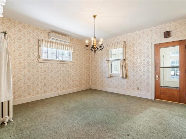 carpeted spare room featuring a chandelier, an AC wall unit, baseboards, and wallpapered walls