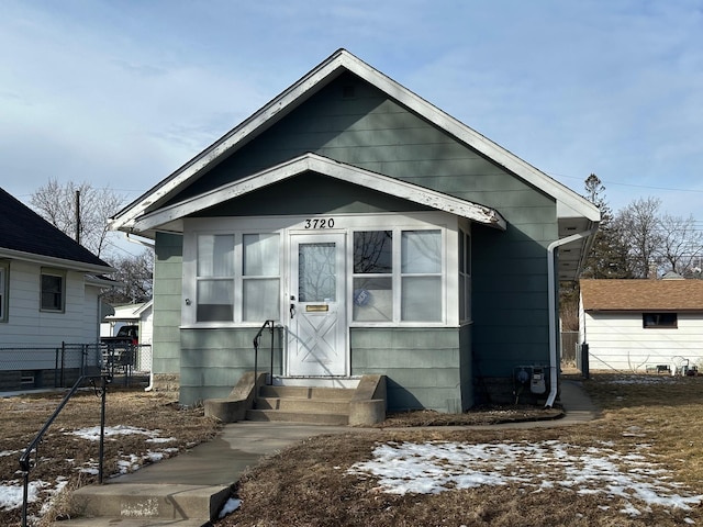 bungalow-style home featuring entry steps and fence