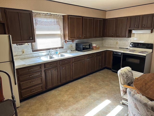 kitchen with electric stove, light countertops, stainless steel microwave, freestanding refrigerator, and a sink