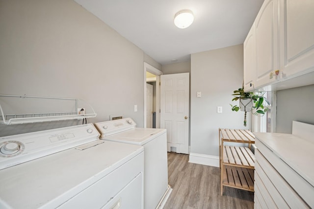 1001 Humboldt Ave W, Saint Paul, MN 55118 - clothes washing area with light wood-style floors, cabinet space, baseboards, and washer and dryer