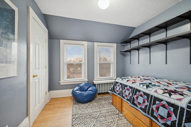 1001 Humboldt Ave W, Saint Paul, MN 55118 - bedroom with a textured ceiling, radiator heating unit, baseboards, lofted ceiling, and light wood-type flooring