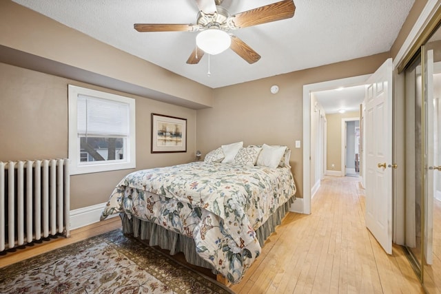 1001 Humboldt Ave W, Saint Paul, MN 55118 - bedroom with radiator, baseboards, light wood-type flooring, and ceiling fan