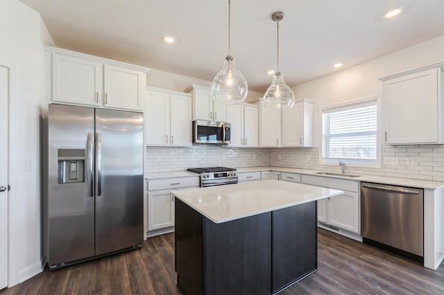 kitchen featuring light countertops, appliances with stainless steel finishes, white cabinetry, and pendant lighting