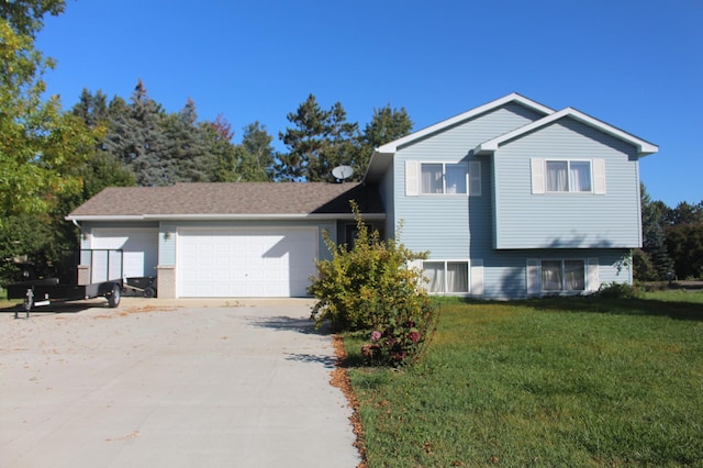 split level home featuring a garage, a front yard, and driveway