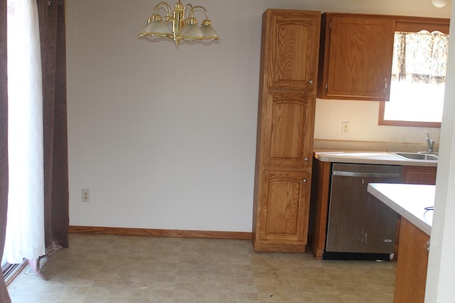 kitchen featuring a sink, light countertops, stainless steel dishwasher, light floors, and brown cabinetry