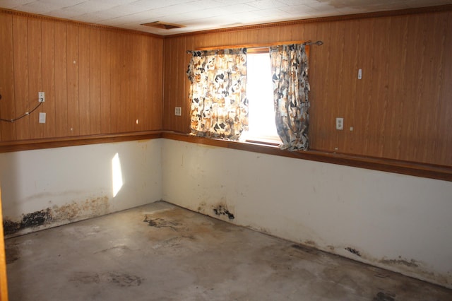 empty room with concrete floors and wooden walls