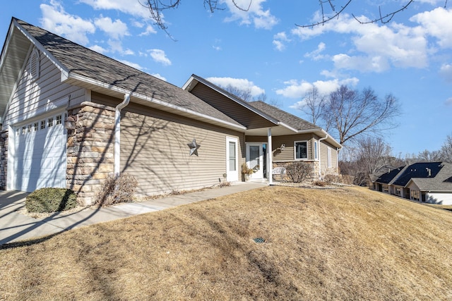 single story home with a garage, a front yard, stone siding, and roof with shingles