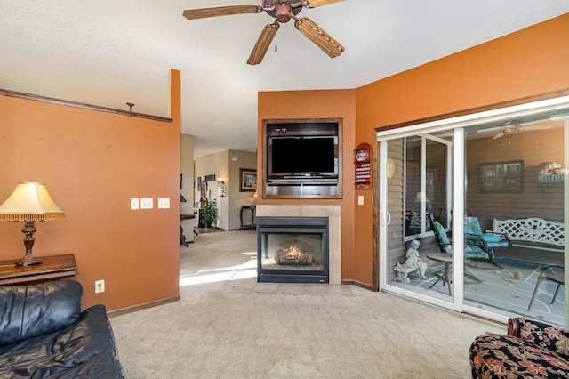 living room with light carpet, ceiling fan, a tile fireplace, and baseboards