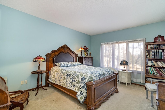 bedroom with baseboards and light colored carpet