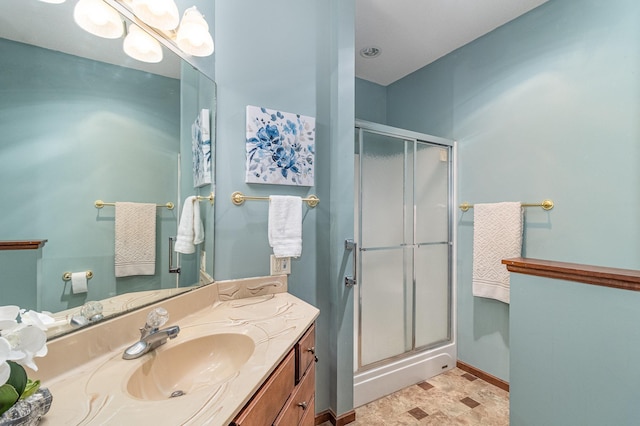 full bath with baseboards, a shower stall, and vanity